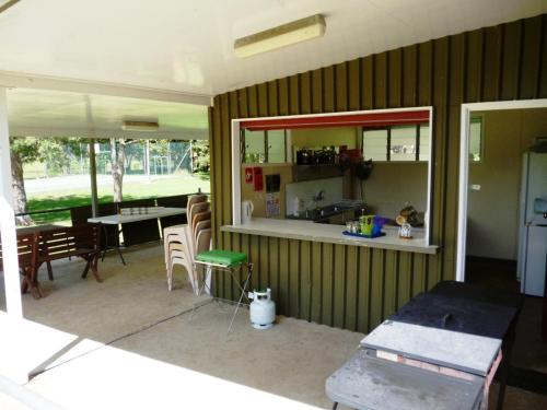 a kitchen and dining room with a table and chairs at Christmas Creek Café & Cabins in Lamington