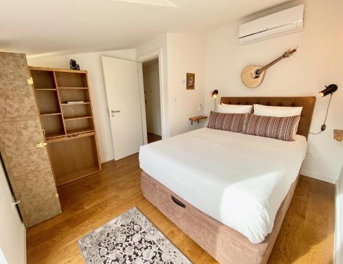 um quarto com uma cama com uma guitarra na parede em Unique apartment by MyPlaceForYou, in the center of Lisbon with views over the city and the Tagus river em Lisboa