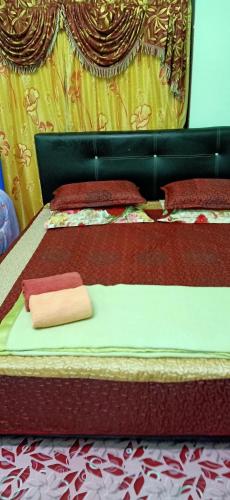 a bed with two beds with red and yellow covers at Homestay Damai Sri Kota in Kepala Batas