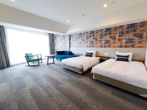 a hotel room with two beds and a couch at Okinawa Grand Mer Resort in Okinawa City
