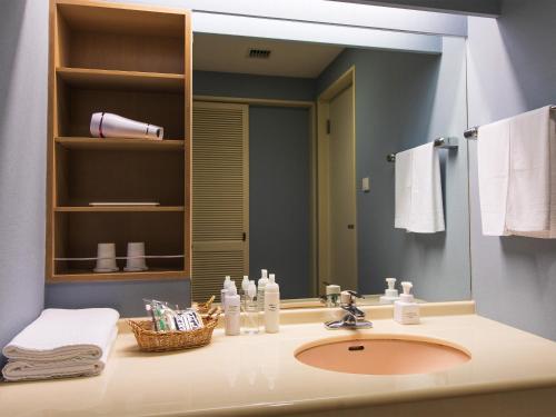 een badkamer met een wastafel en een grote spiegel bij Okinawa Grand Mer Resort in Okinawa City