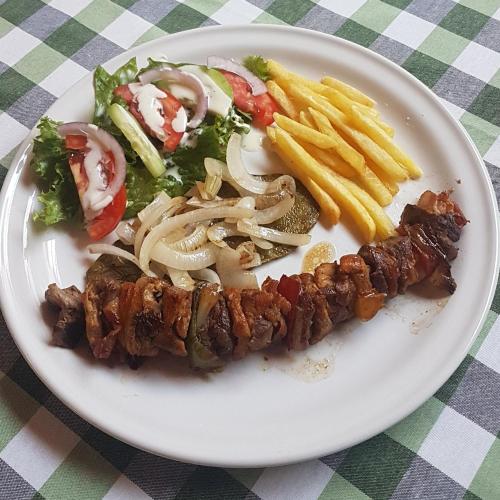 a plate of food with meat and french fries at HI Huasteca Inn Hotel in Matlapa