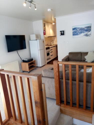 a living room with a couch and a flat screen tv at Shamrock Apartment 5 in Mount Hotham