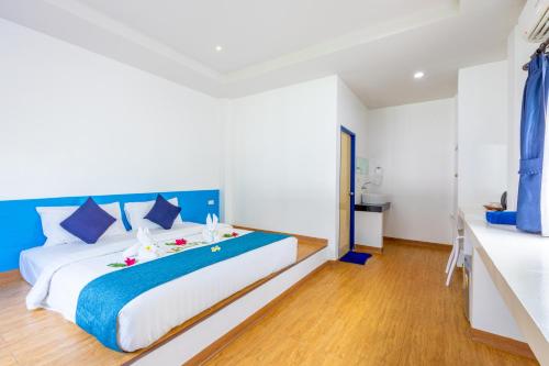 a bedroom with a large bed with blue accents at Three Trees Samui Resort - Sarocha Villa in Lamai
