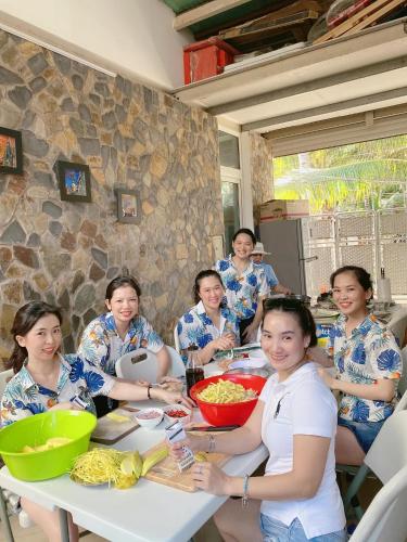 ムイネーにあるQli Hotelのテーブルに食べ物を持って座っている女性たちのグループ