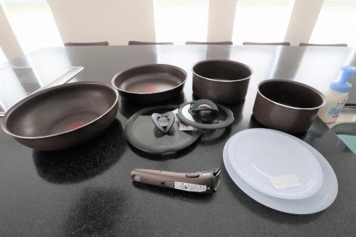 a counter top with four pans and a plate and a spatula at 暖炉之宿 コンセプトハウス星田 in Katano