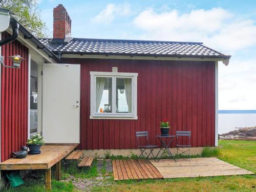 a red house with two chairs and a table at 2 person holiday home in FR NDEFORS in Frändefors
