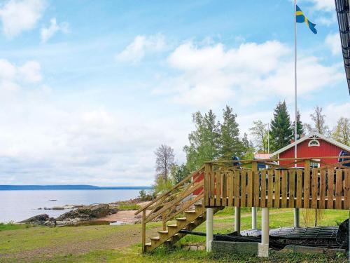 uma escada de madeira ao lado de uma casa vermelha com uma bandeira em 2 person holiday home in FR NDEFORS em Frändefors