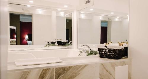 uma casa de banho com uma banheira e um espelho grande em Best Western Plus Bowmanville em Bowmanville