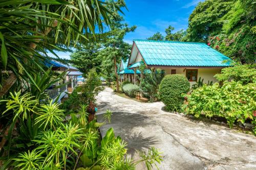 a path leading to a house with a blue roof at Three Trees Samui Resort - Sarocha Villa in Lamai