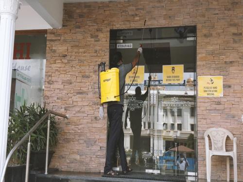 two men are painting a window of a building at Heritage Inn in Mysore