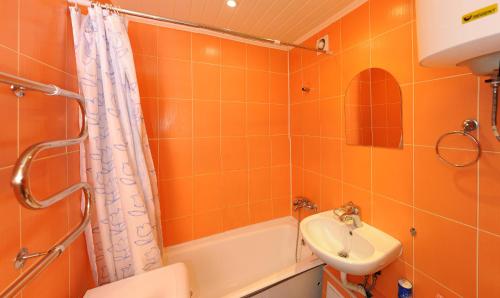 オムスクにあるApartment on Karla Marksa 37のオレンジ色のバスルーム(シンク、シャワー付)