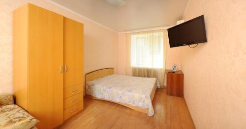 オムスクにあるApartment on Karla Marksa 37のベッドルーム1室(ベッド1台、壁掛けテレビ付)