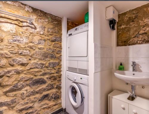 a bathroom with a washing machine and a sink at Petit Château de Harzé in Aywaille