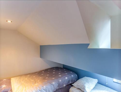 a small room with a bed in a attic at Petit Château de Harzé in Aywaille