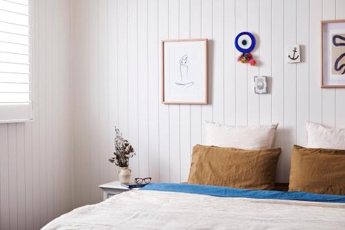 a bedroom with a white bed and a blue wall at Anchor Geelong in Geelong