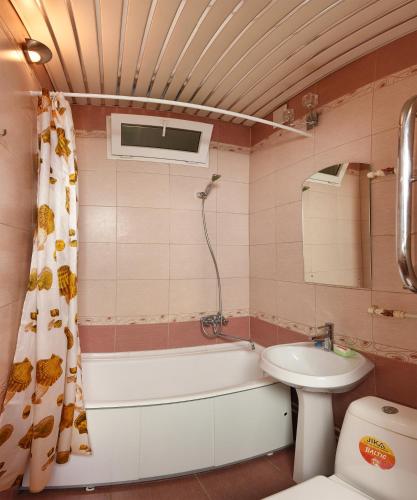 オムスクにあるOmsk Sutki Apartments Krasny Put 67のバスルーム(バスタブ、洗面台、トイレ付)