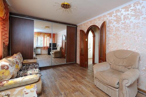 オムスクにあるOmsk Sutki Apartments on Gagarina 2のリビングルーム(椅子、鏡付)