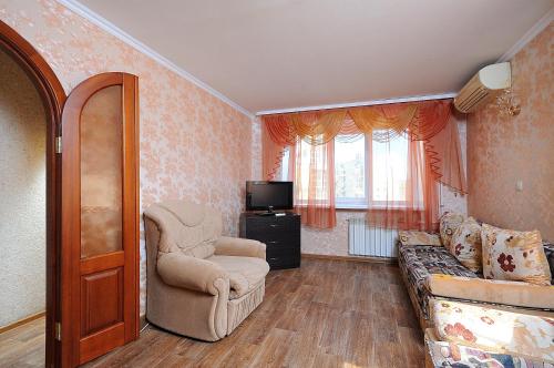 オムスクにあるOmsk Sutki Apartments on Gagarina 2のリビングルーム(ソファ、椅子付)