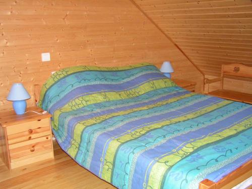 a bedroom with a bed and a night stand with two lamps at chalet cathy in Laveissière