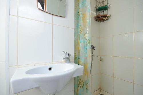 a bathroom with a white sink and a mirror at Omsk Sutki Apartments on Mira 10 in Omsk