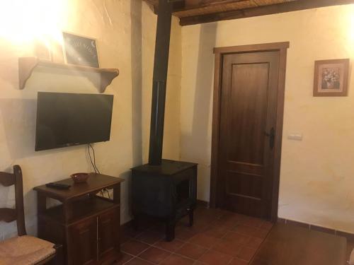 a living room with a stove and a television at Casa Rural Cortijo La Ajedrea in Siles