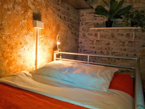 una cama en una habitación con una pared de ladrillo en Zen Harmony House Sydney, en Sídney