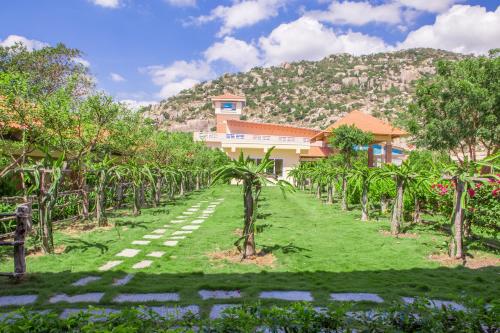 a plantation of palm trees in front of a building at Hòn Cò Resort - Cà Ná in Thôn Lạc Nghiệp