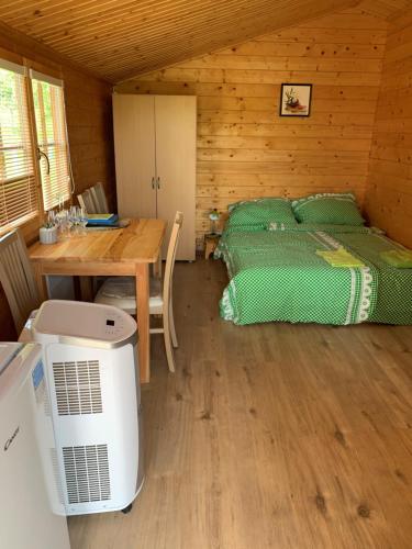 ein Schlafzimmer mit einem Bett und einem Tisch in einer Hütte in der Unterkunft Ubytovani U lišáka FOXE in Bulhary