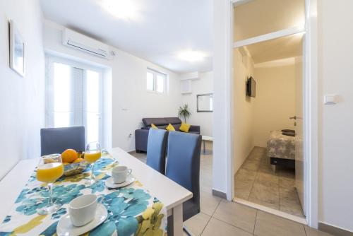 comedor y sala de estar con mesa y sillas en Tinker Bell Apartment, en Dubrovnik