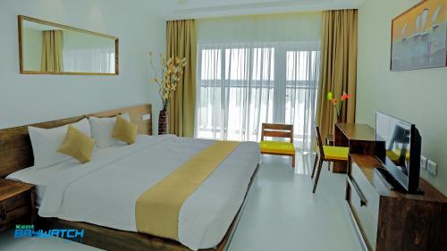 a bedroom with a large bed and a television at Kent Baywatch Suites in Cochin