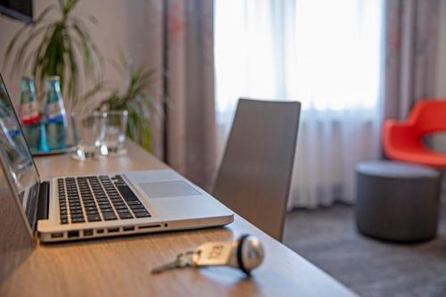 a laptop computer sitting on top of a wooden table at Hotel Alte Bäckerei in Nidderau