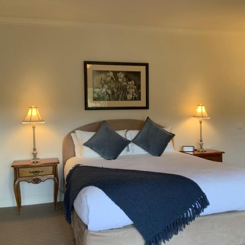 a bedroom with a large bed with two lamps at Delderfield Villas Adults Retreat in Marysville