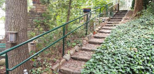 a set of stone stairs with a green railing at Bungalow am Donnerberg in Sewekow in Sewekow