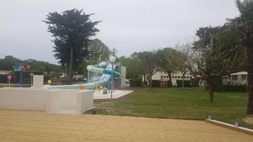 une aire de jeux avec un toboggan dans un parc dans l'établissement mobil home, à Médis