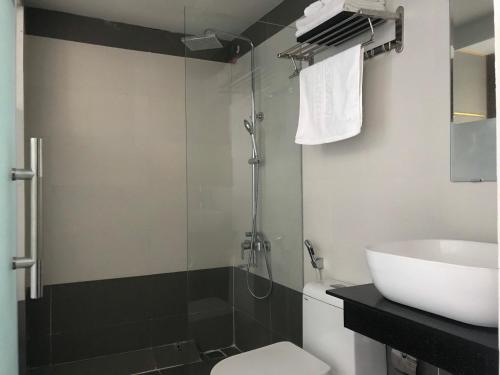 e bagno con doccia, servizi igienici e lavandino. di ABAY Hotel a Nha Trang