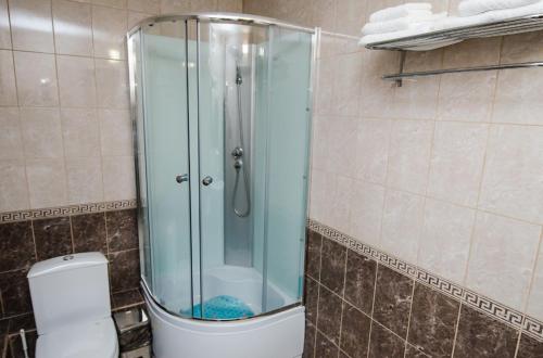 a glass shower in a bathroom with a toilet at Uralochka Hotel in Chelyabinsk