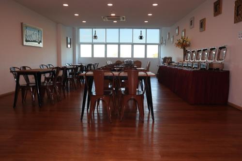 a dining room with wooden tables and chairs at Aman Hills Hotel in Kampong Timbunan