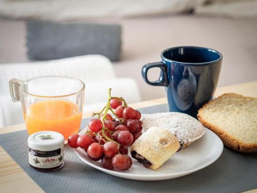 a plate of food with a glass of orange juice and a plate of fruit at Affittacamere Ai Crocus in Cesclans