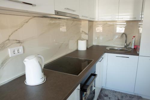 a white kitchen with a sink and a counter at Novi Pazar APARTMAN LUX 2 in Novi Pazar