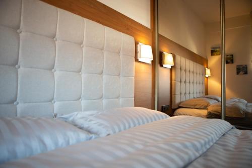 a bedroom with two white beds and a mirror at Novi Pazar APARTMAN LUX 2 in Novi Pazar