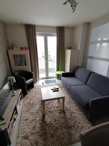 オーステンデにあるApartment Frankyの青いソファとテーブルのあるリビングルーム