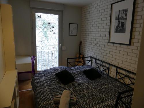 a bedroom with a bed and a brick wall at Appt T3, 55m2 proche Parc Tête D'or et quais du Rhône in Caluire-et-Cuire