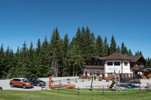 um grande edifício com carros estacionados num parque de estacionamento em Sonnalm em Altenmarkt im Pongau