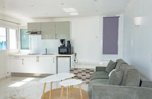 a living room with a couch and a kitchen at Hotel et Appartements Reine D'Azur in Roquebrune-Cap-Martin