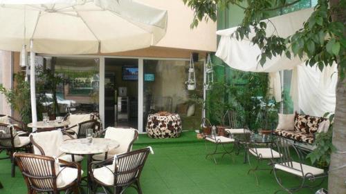 an outdoor patio with tables and chairs and an umbrella at Sea Horse in Burgas City