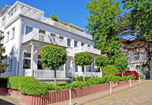 a white house with a fence in front of it at Ferienappartement mit Ostseeblick in Göhren