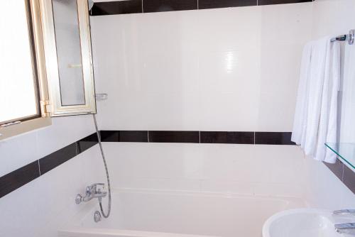 a bathroom with a bath tub and a sink at Hotel et Appartements Reine D'Azur in Roquebrune-Cap-Martin