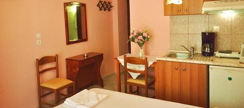 a kitchen with a sink and a table and chairs at Agyra Villa in Limenaria