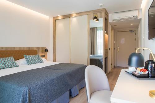 pokój hotelowy z łóżkiem i stołem w obiekcie Hotel Presidente 4 sup w mieście Benidorm
